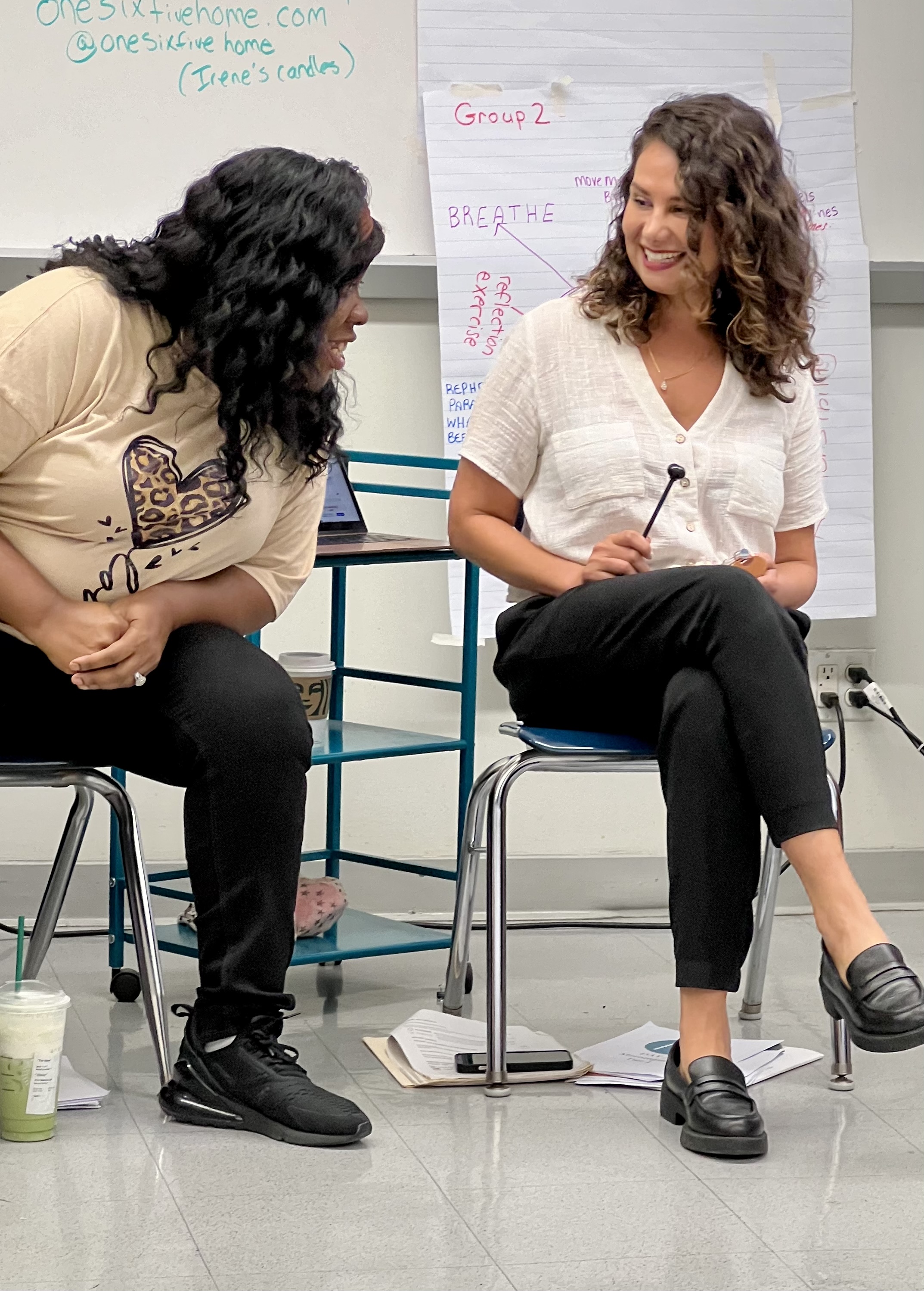 Iris (right) speaking with a participant in a training