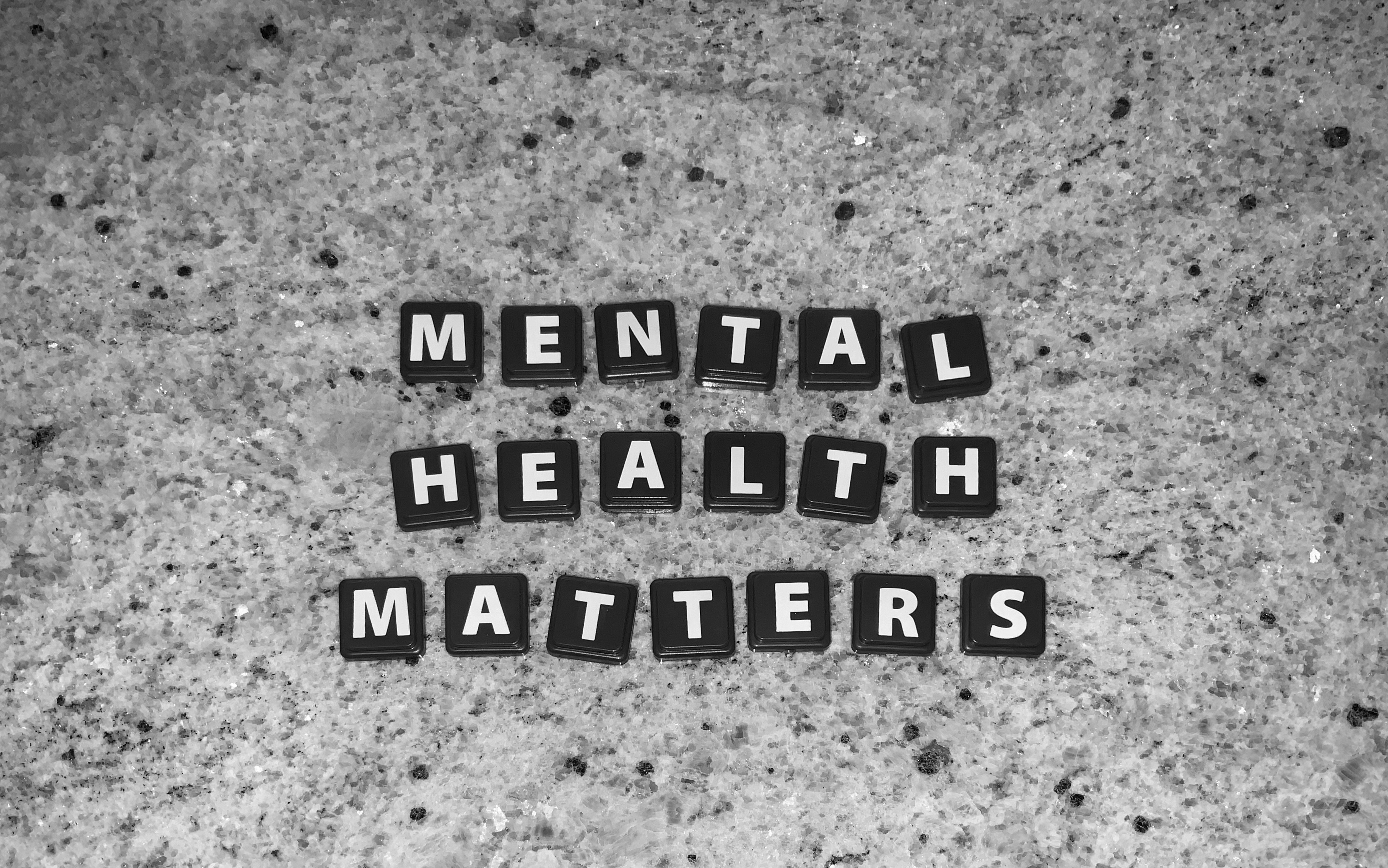 tiles on a grey background that spell out "mental health matters"